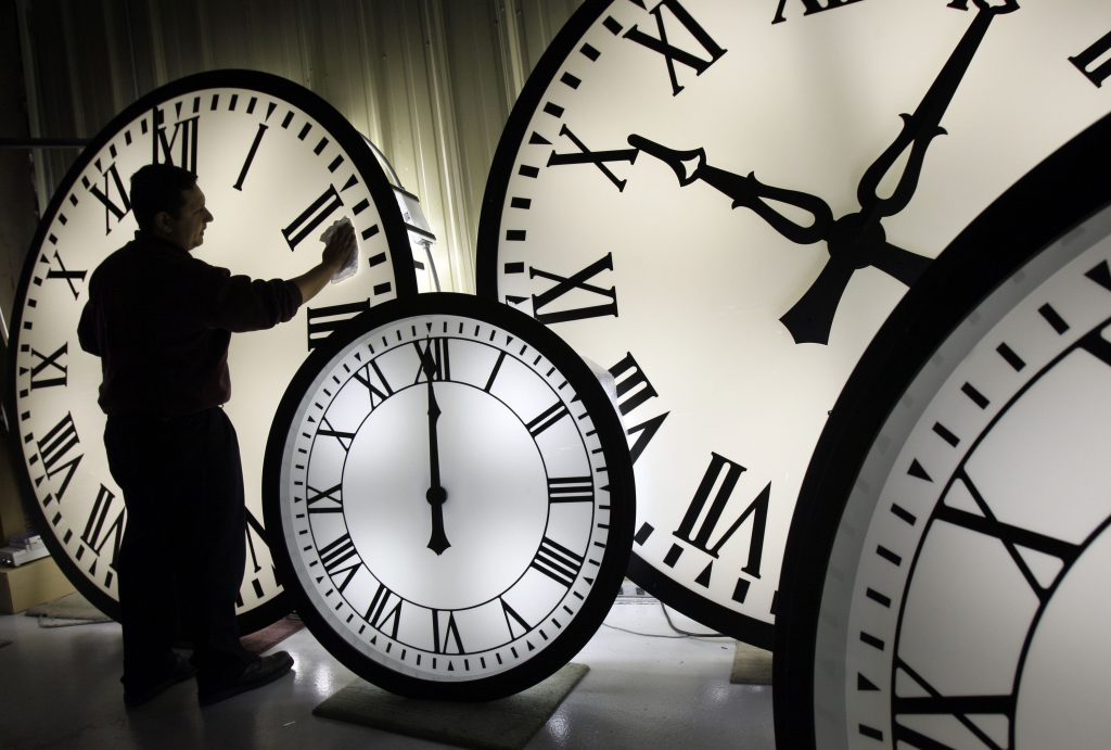 picture of man next to clocks