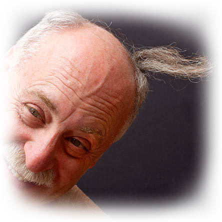 Close-up of a bald man's small piece of hair flapping in the wind.